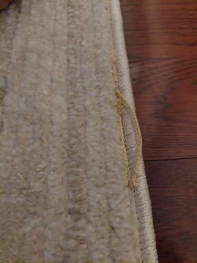 Customer photo for review titled "The rug arrived with defect it is unstitched....."