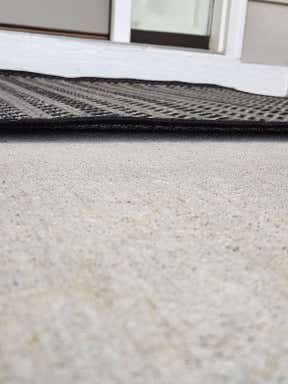 Customer photo for review titled "Rugs curls up on edges- tripping hazard"