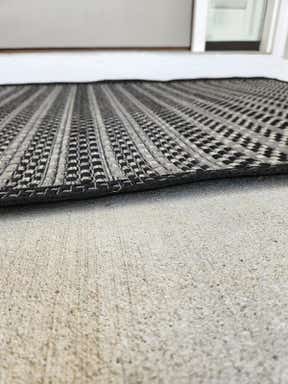 Customer photo for review titled "Rugs curls up on edges- tripping hazard"