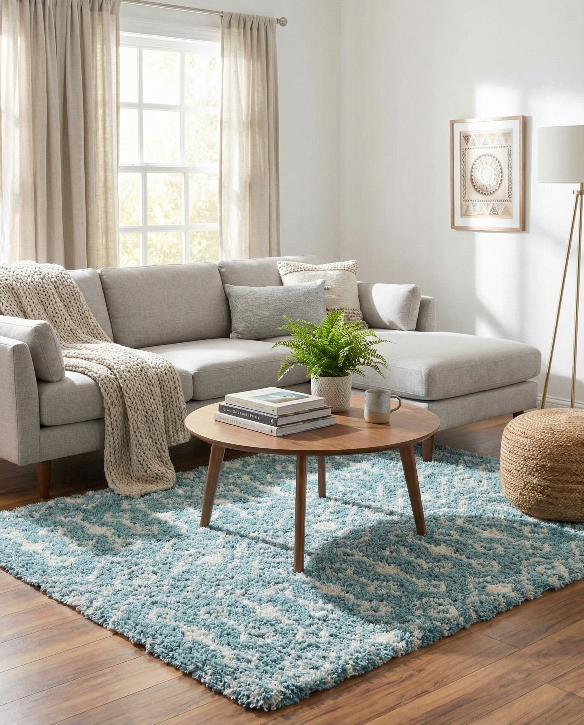 A square light blue shag rug with a cream tribal pattern, featuring diamonds and abstract motifs.