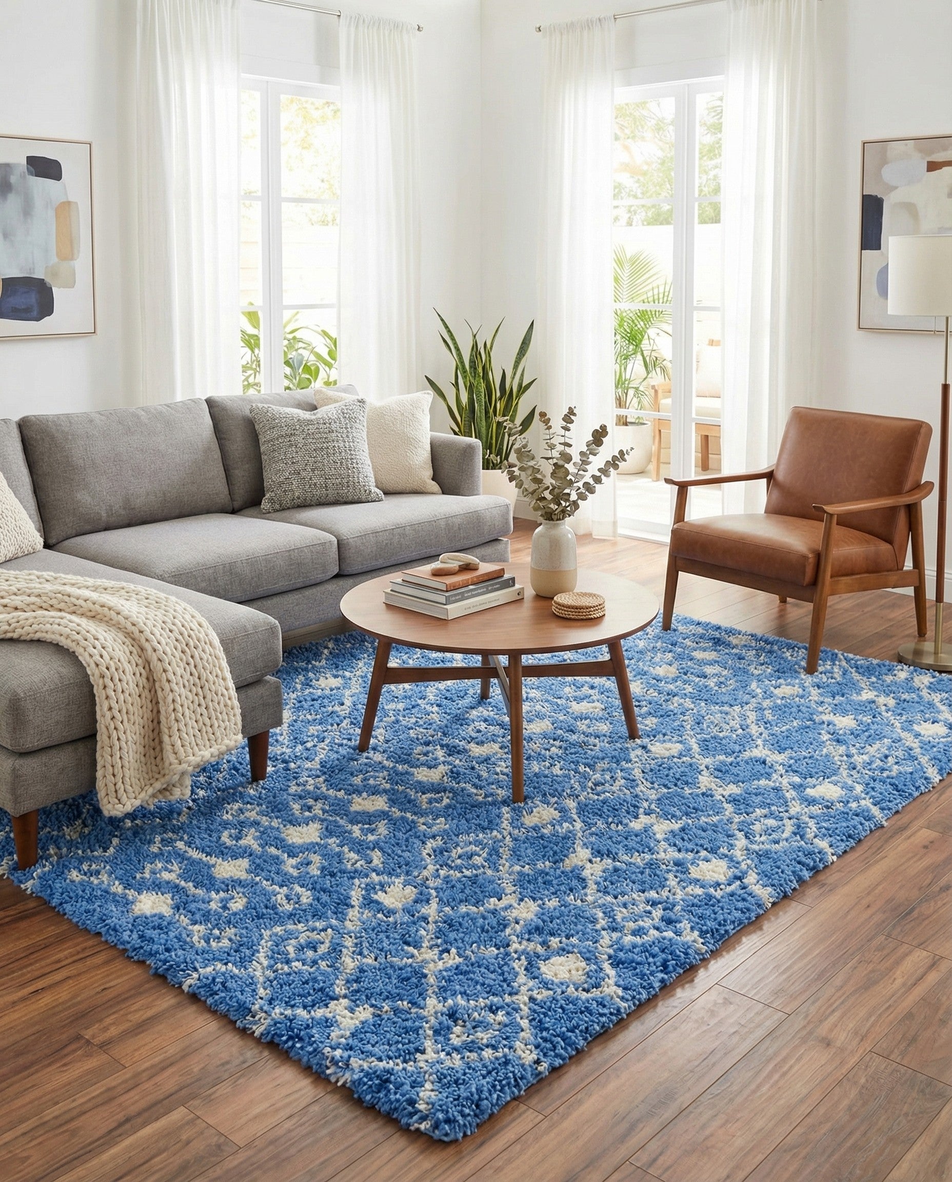 A 10x14 rectangular blue shag rug with a white tribal geometric pattern, featuring diamonds and zigzags.