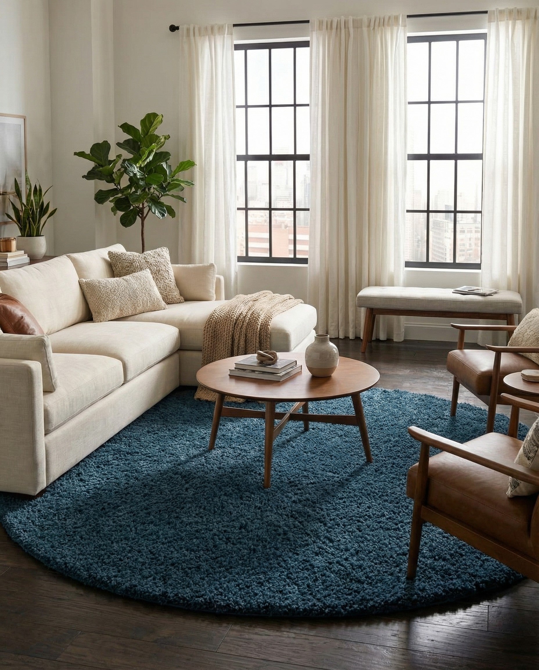 A large 12' 4 round navy blue shag rug, made from polypropylene, offering a soft, textured surface.