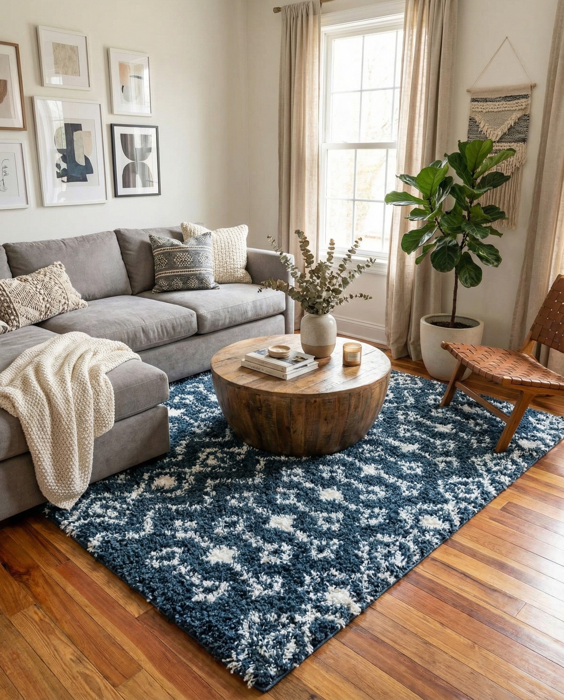 A square navy blue shag rug with a white modern tribal pattern, featuring diamond and zigzag motifs.