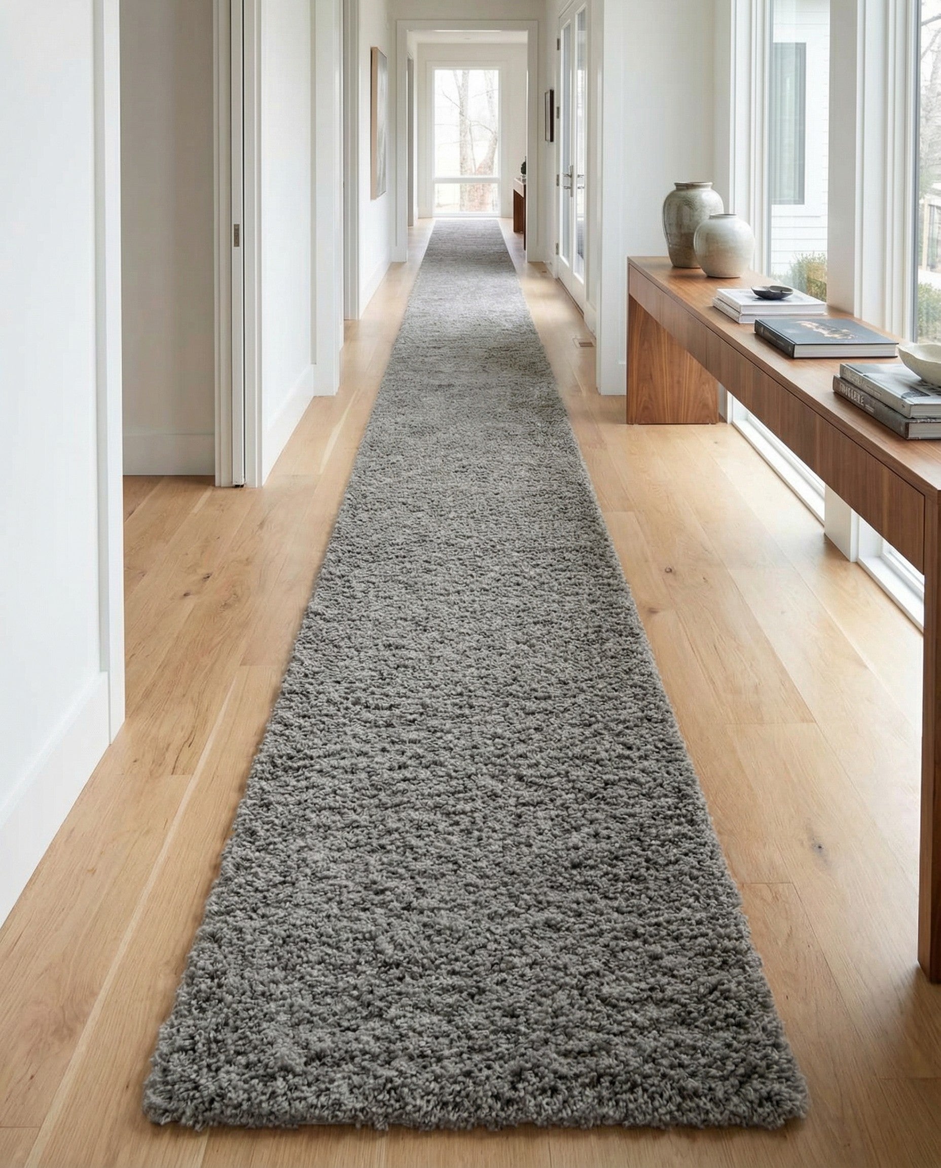 A long, rectangular 20 ft runner rug from the Rugs.com Solid Shag collection, featuring a thick, textured gray shag pile, ideal for a hallway.