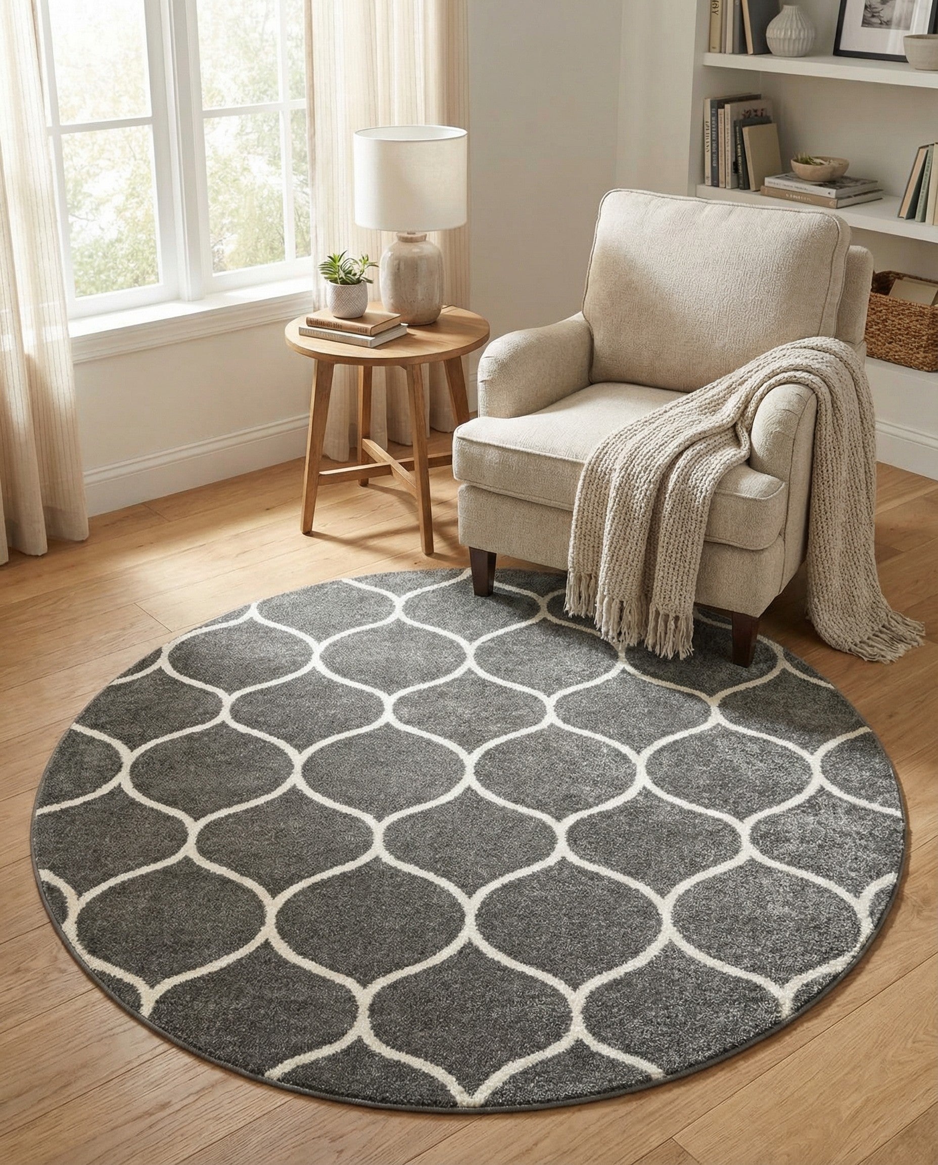 A 5' 3 round gray area rug featuring a modern white trellis pattern, suitable for various indoor rooms.