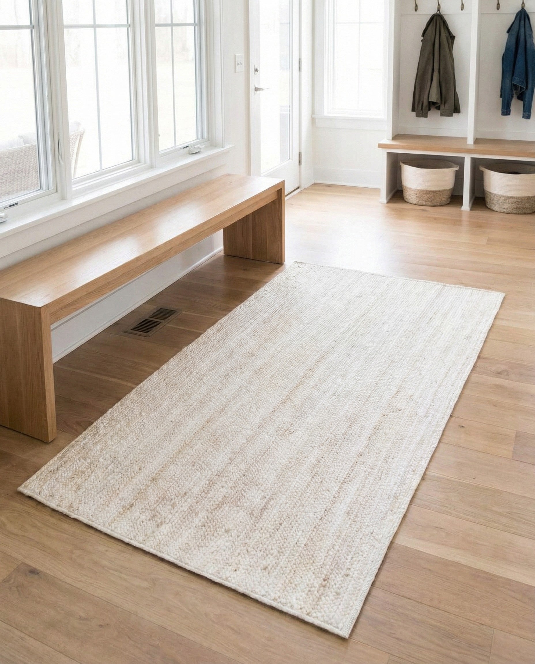 A 3x5 rectangular white braided jute rug with a minimalist, textured flatweave pattern, ideal for various indoor spaces.